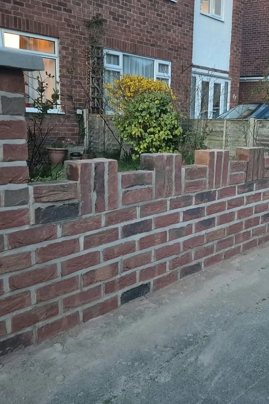 New brick boundary wall and pillar built by RLG Construction, with the houses behind
